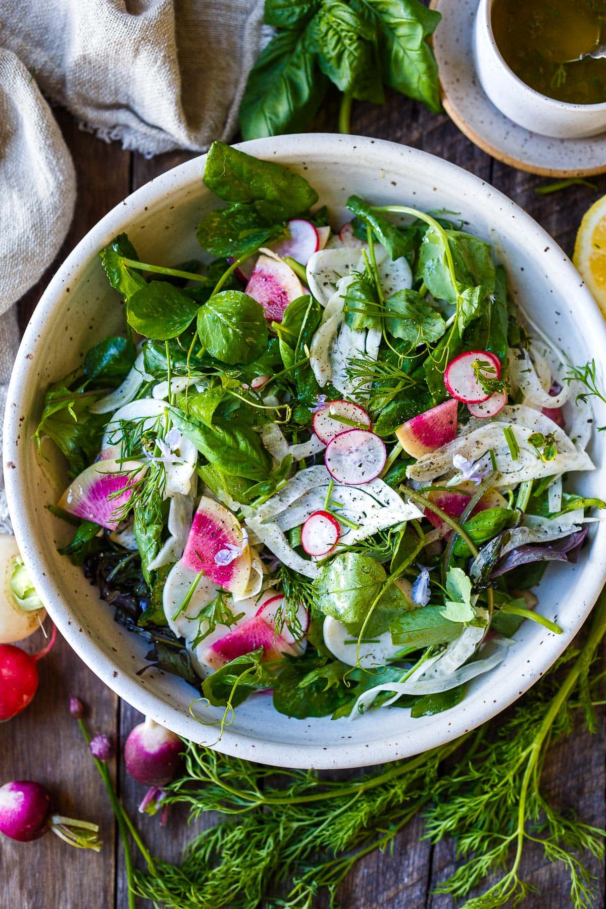 Simple, herby, and delicious, this spring salad recipe is made with tender spring greens, fresh herbs, shaved fennel, and radishes tossed in a lemon dressing