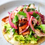 Salmon tacos with avocado, cabbage fennel slaw, ad taco sauce.