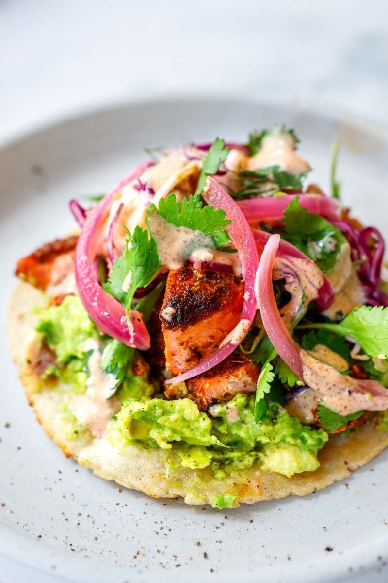 Salmon tacos with avocado, cabbage fennel slaw, ad taco sauce.