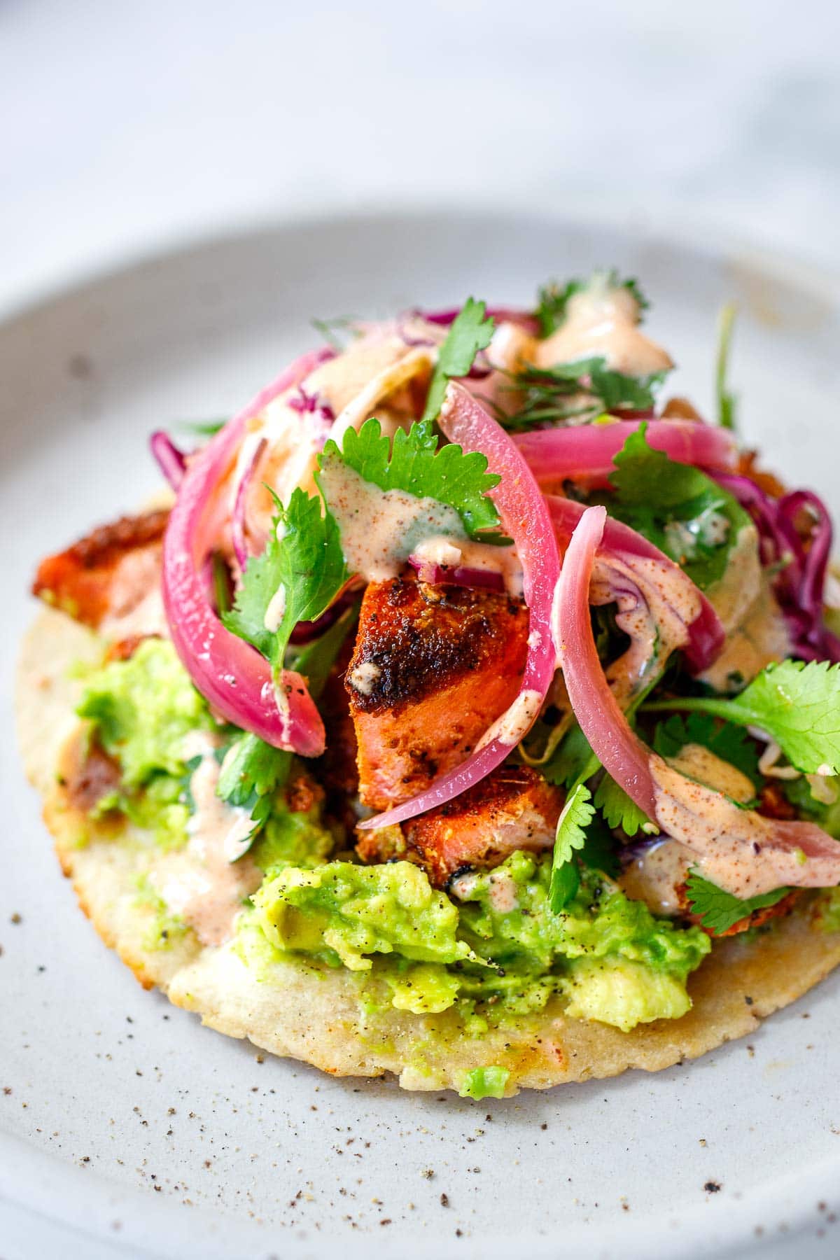 Salmon tacos with avocado, cabbage fennel slaw, ad taco sauce.