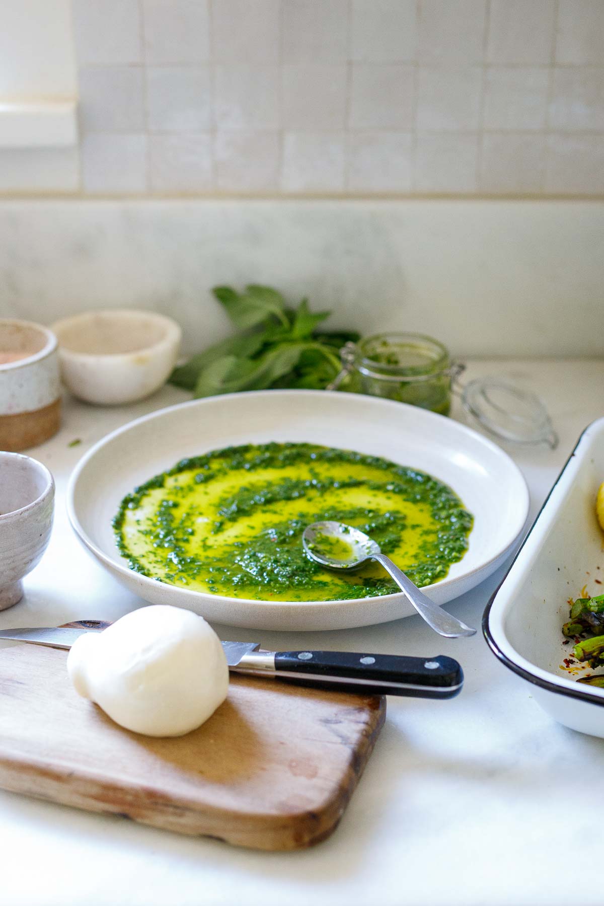 Spreading basil oil on the plate.