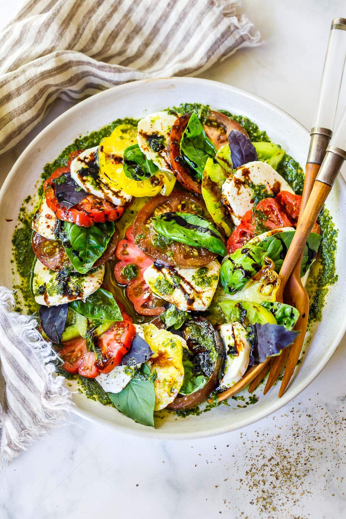 This Caprese salad is made with heirloom tomatoes, fresh mozzerella cheese, basil oil and a balsamic glaze. 