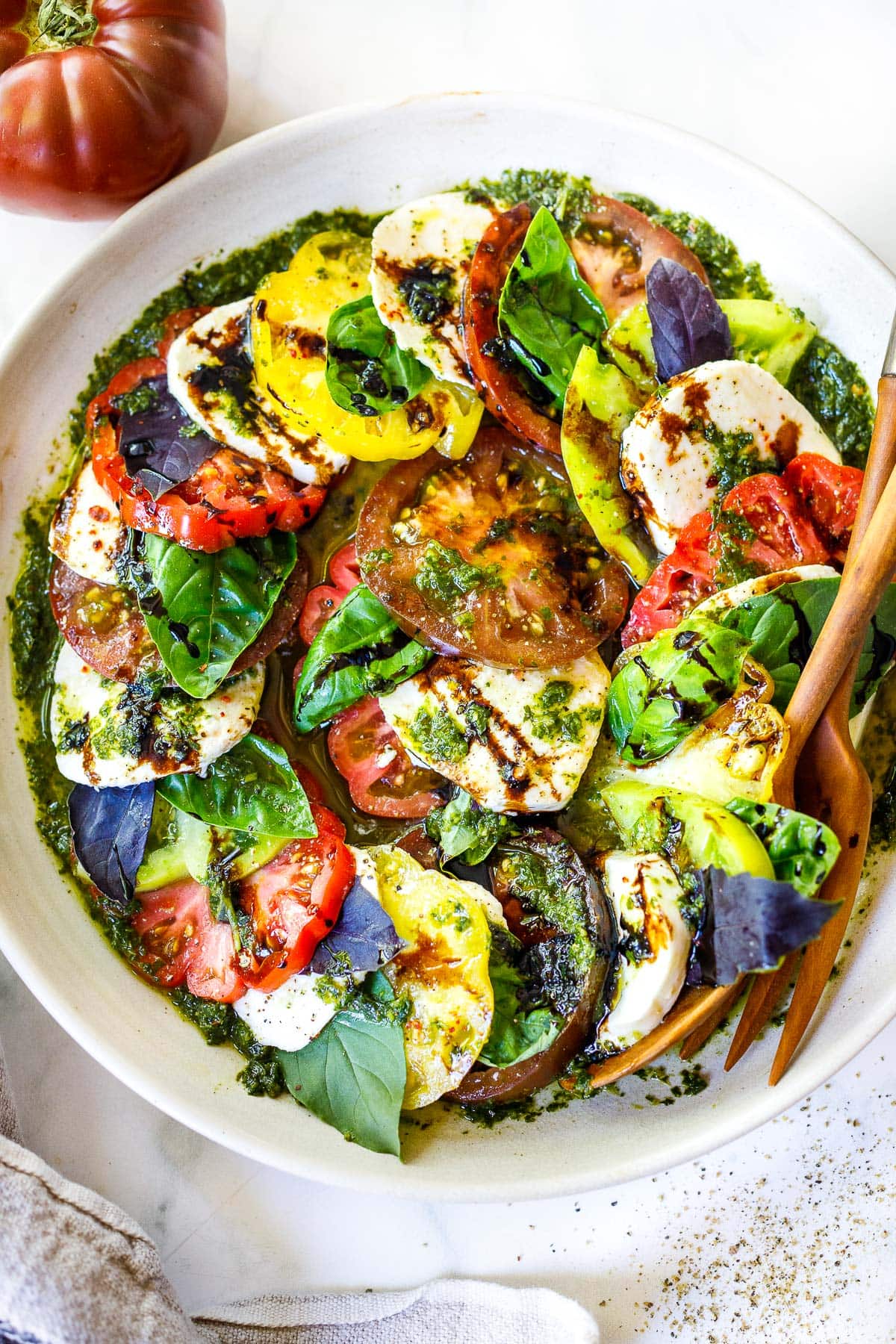 You'll love this Caprese Salad! Made with juicy summer tomatoes, fresh mozzarella cheese, basil leaves, and a balsamic glaze, we give it a little "upgrade" with Basil Oil.