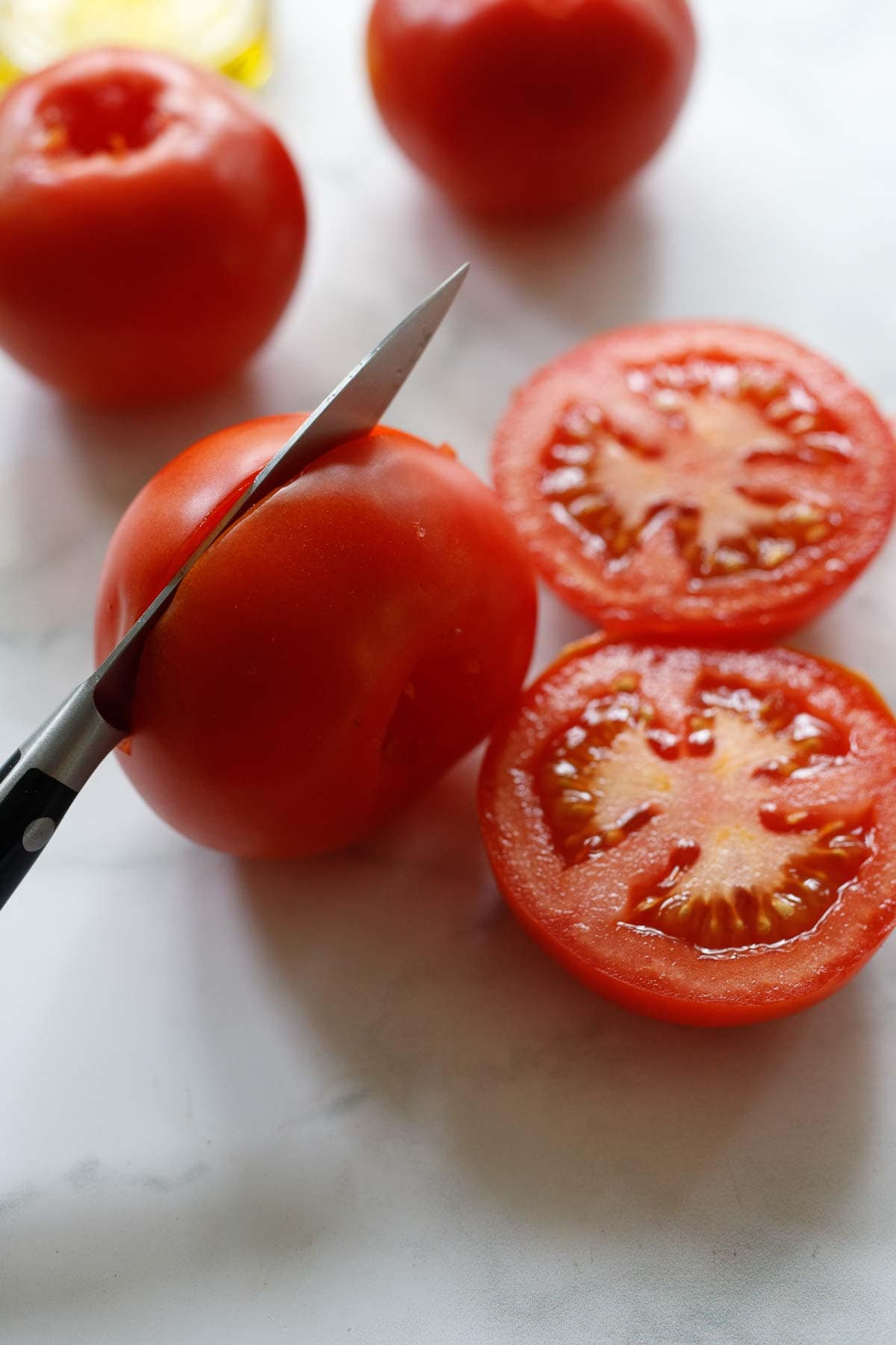 slicing the tomatoes in half.