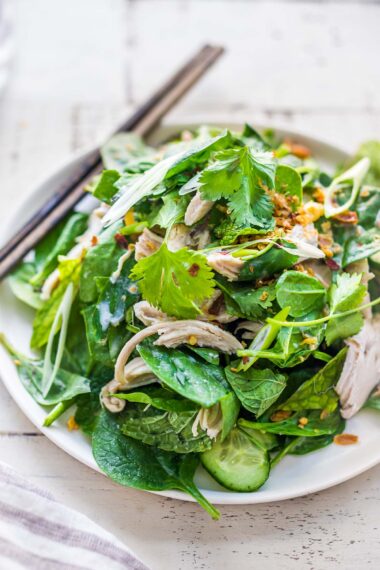 A tasty recipe for Thai Chicken Salad with baby spinach, cucumber, mint, cilantro, and scallions with crispy shallots. A flavorful entree salad perfect for warm summer nights.