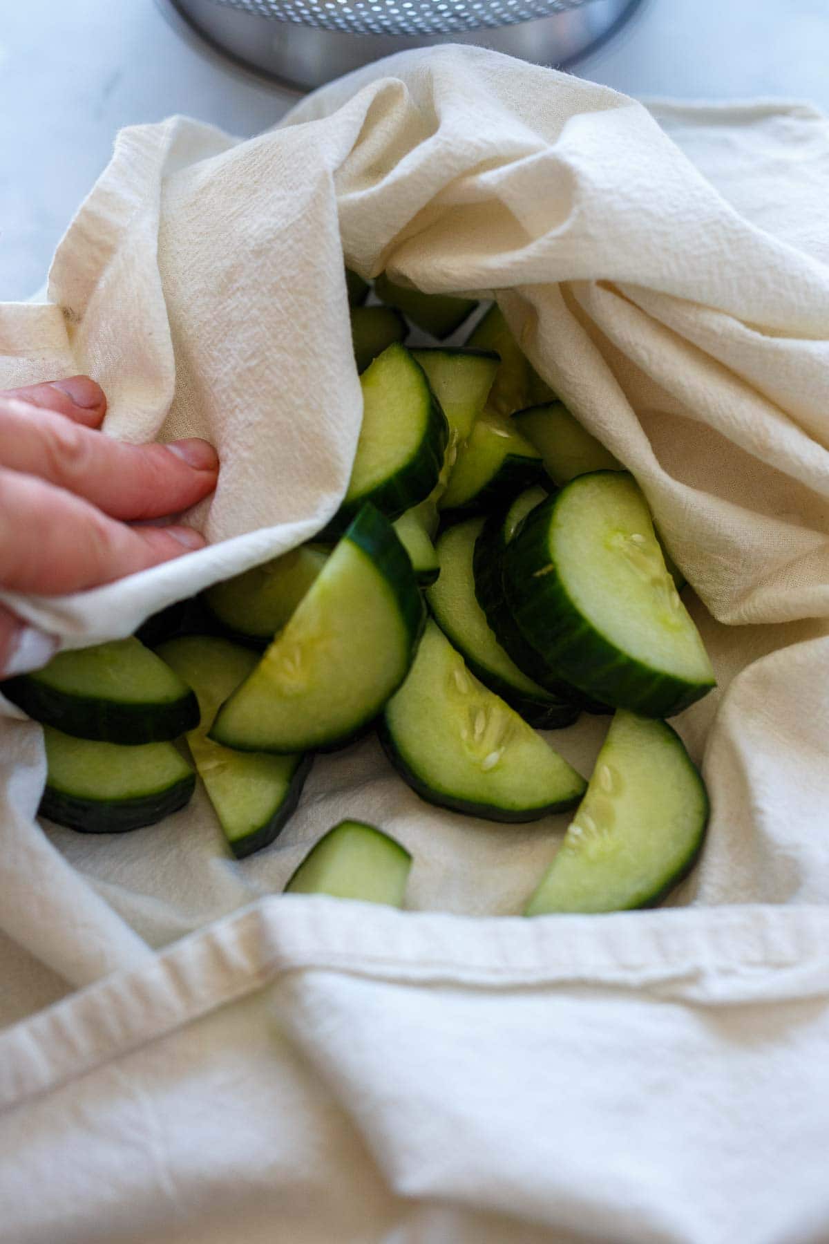 Patting dry salted cucumbers for Korean Cucumber Salad.