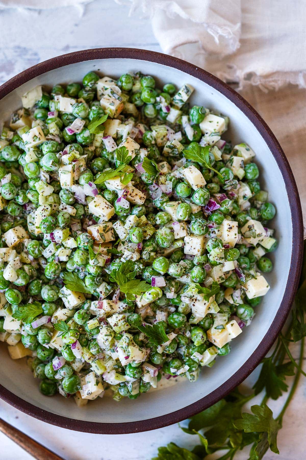 A healthy spruced-up version of classic Pea Salad tossed in a creamy Greek yogurt dressing with lots of fresh herbs and smoked cheese. Tangy, delicious, and made in one bowl in about 20 minutes! Vegetarian, GF, Vegan-adaptable!