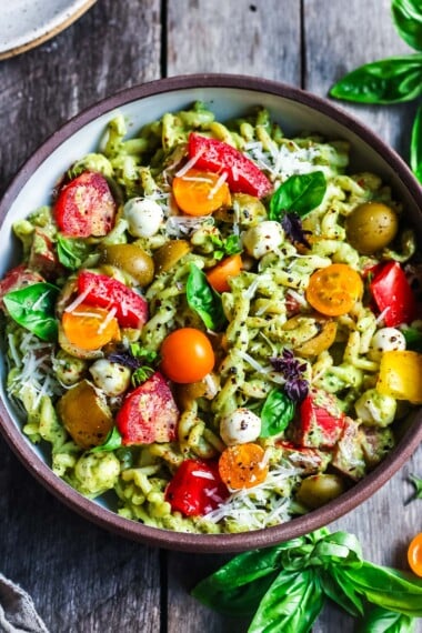 Pesto Pasta Salad w/ cherry tomatoes, baby mozzarella, olives & fresh basil tossed in a Creamy Pesto Dressing. Vegan, gluten-free adaptable.