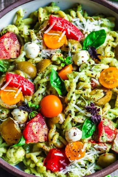 Pesto Pasta Salad w/ cherry tomatoes, baby mozzarella, olives & fresh basil tossed in a Creamy Pesto Dressing. Vegan, gluten-free adaptable.