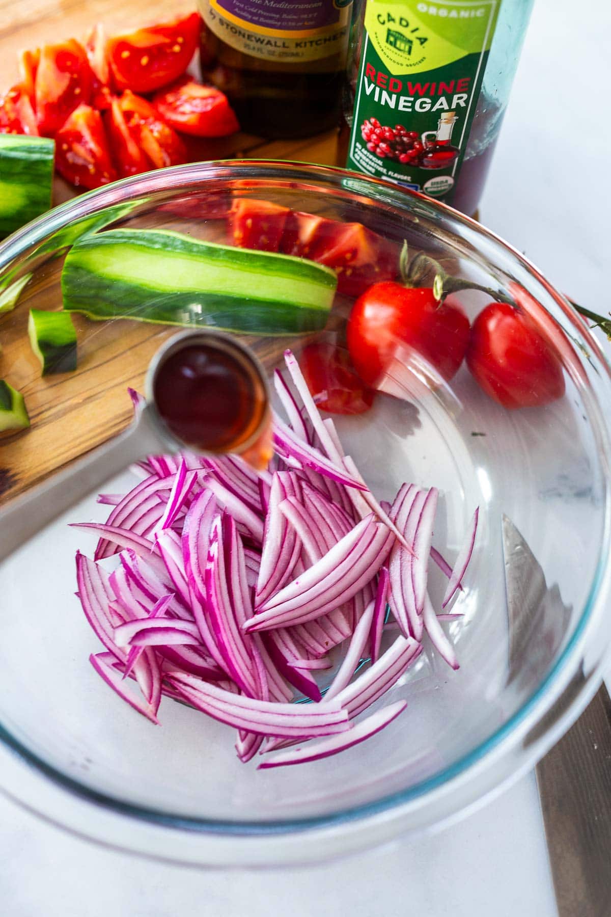 Slivered red onions in a bowl for Cucumber & Tomato Salad.
