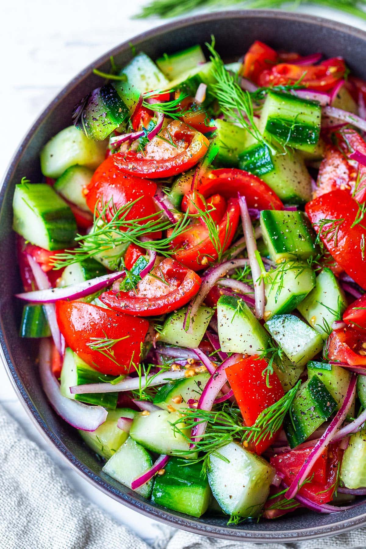 Looking for a light and healthy summer salad? This quick & easy Cucumber Tomato Salad is fresh and light, made with vine-ripe tomatoes and juicy cucumbers, slivers of red onion, and fresh dill, tossed in a red-wine vinaigrette. 