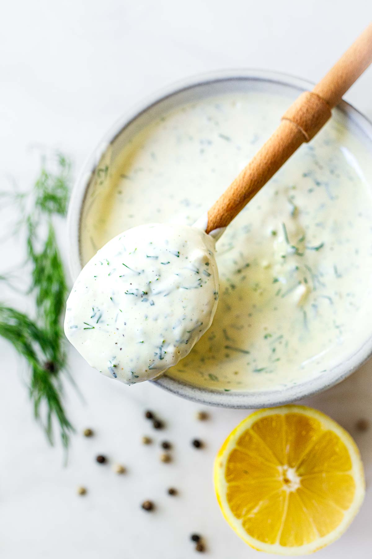 Creamy Dill Sauce  in a bowl with a spoon. Fresh and flavorful- perfect for salmon. 