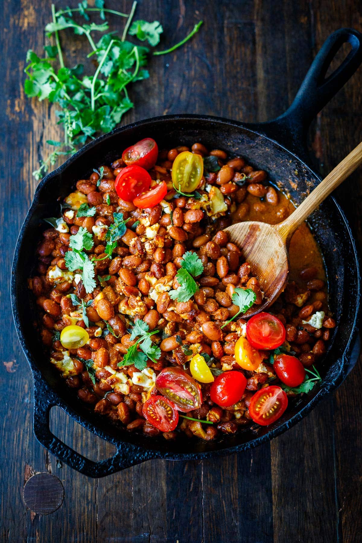 Baked pinto beans beans topped with tomatoes and cilantro 