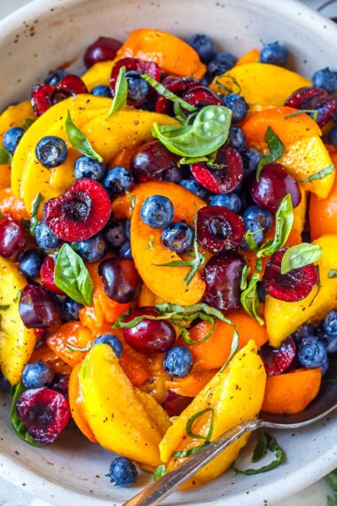 This luscious Fruit Salad is made with summer ripe stone fruit and berries. Cherries, peaches, and apricots along with blueberries and fresh basil- tossed in a delicious vanilla balsamic dressing.