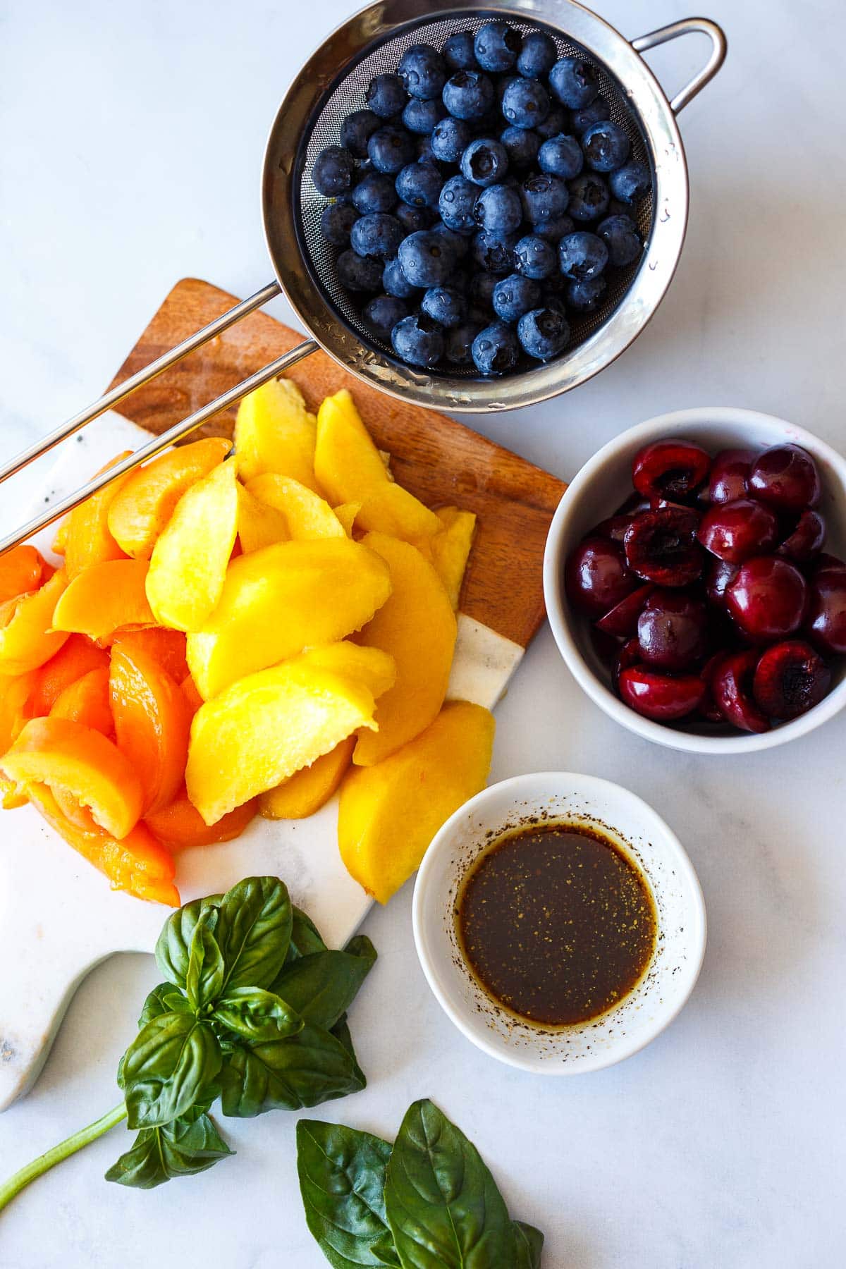 Cut up cherries, peaches and apricots for fruit salad.