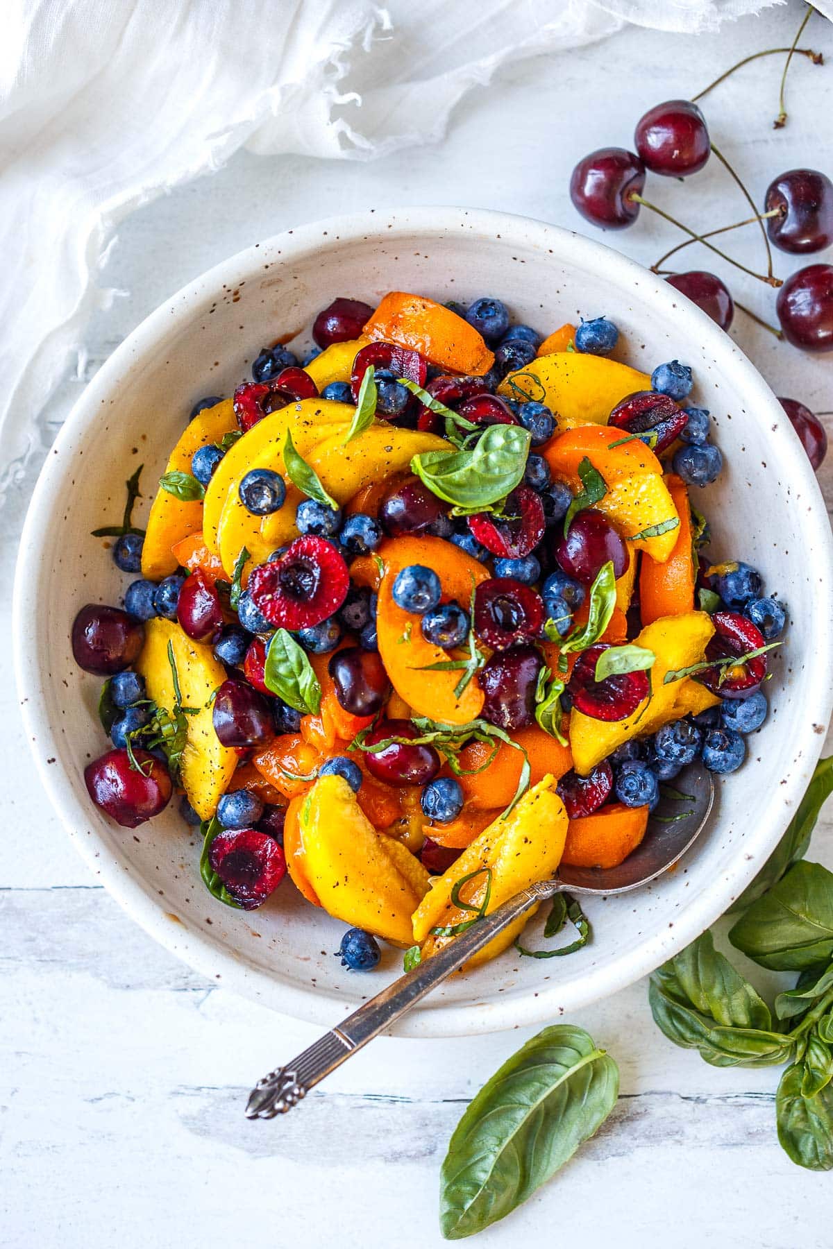 A fruit salad made with peaches and blueberries. 