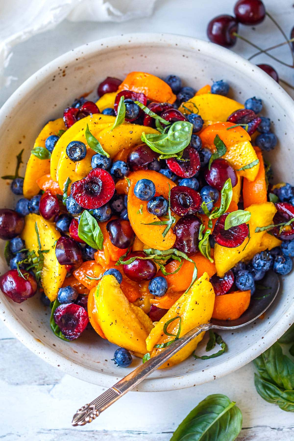 This luscious Fruit Salad is made with summer ripe stone fruit and berries. Cherries, peaches, and apricots along with blueberries and fresh basil- tossed in a delicious vanilla balsamic dressing.