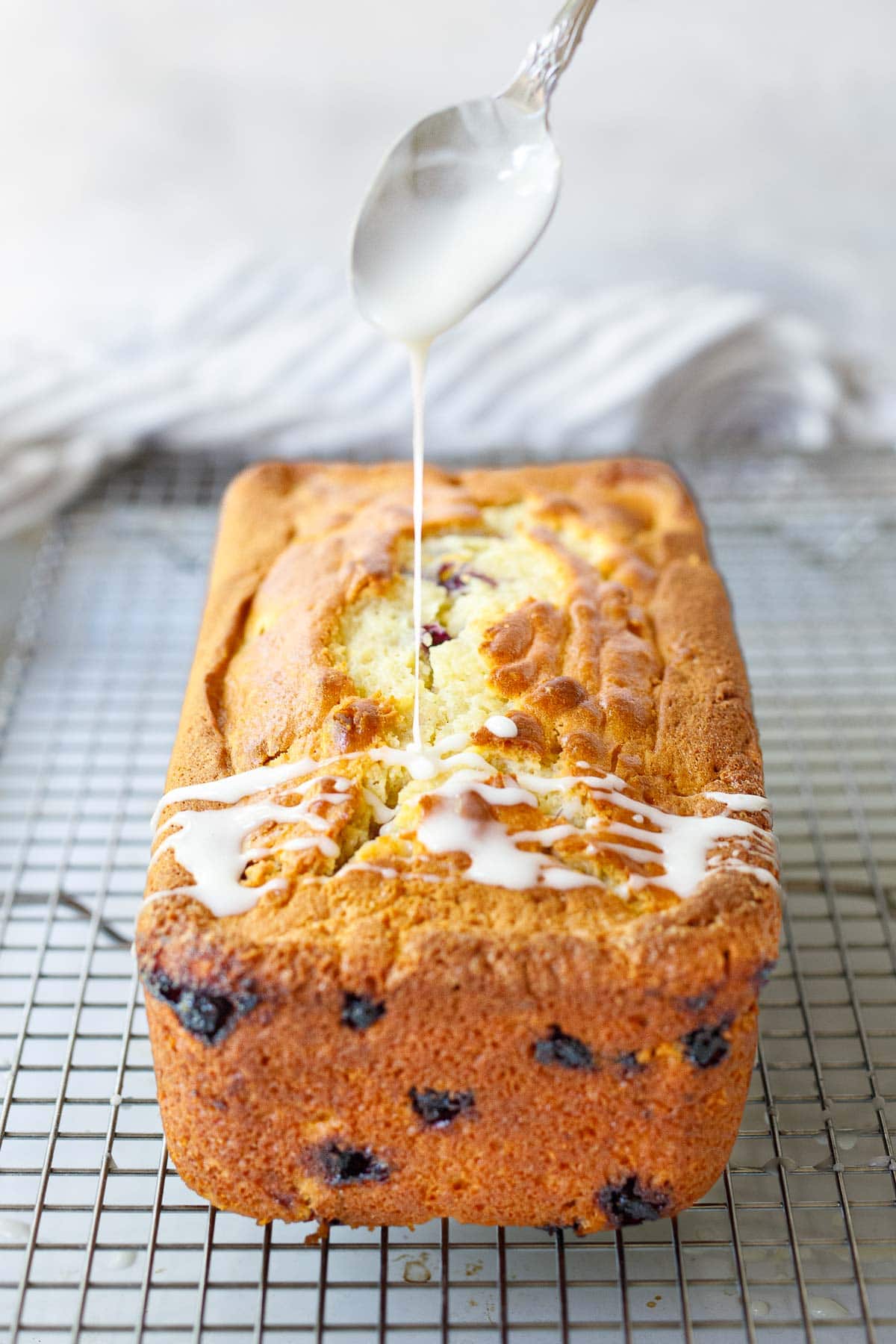 Drizzling lemon glaze over the Huckleberry cake.