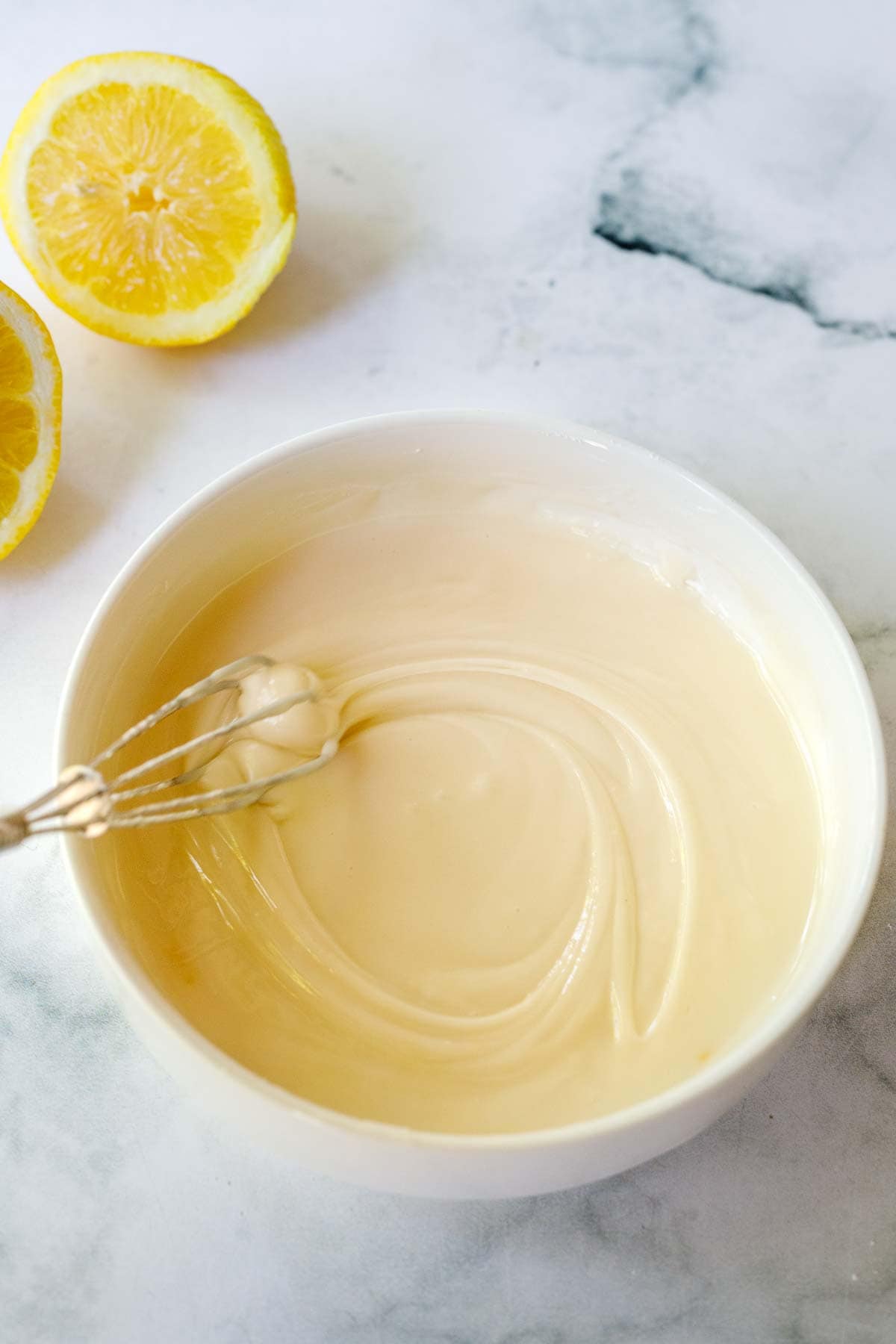 Lemon Glaze in a bowl with a mini whisk. 