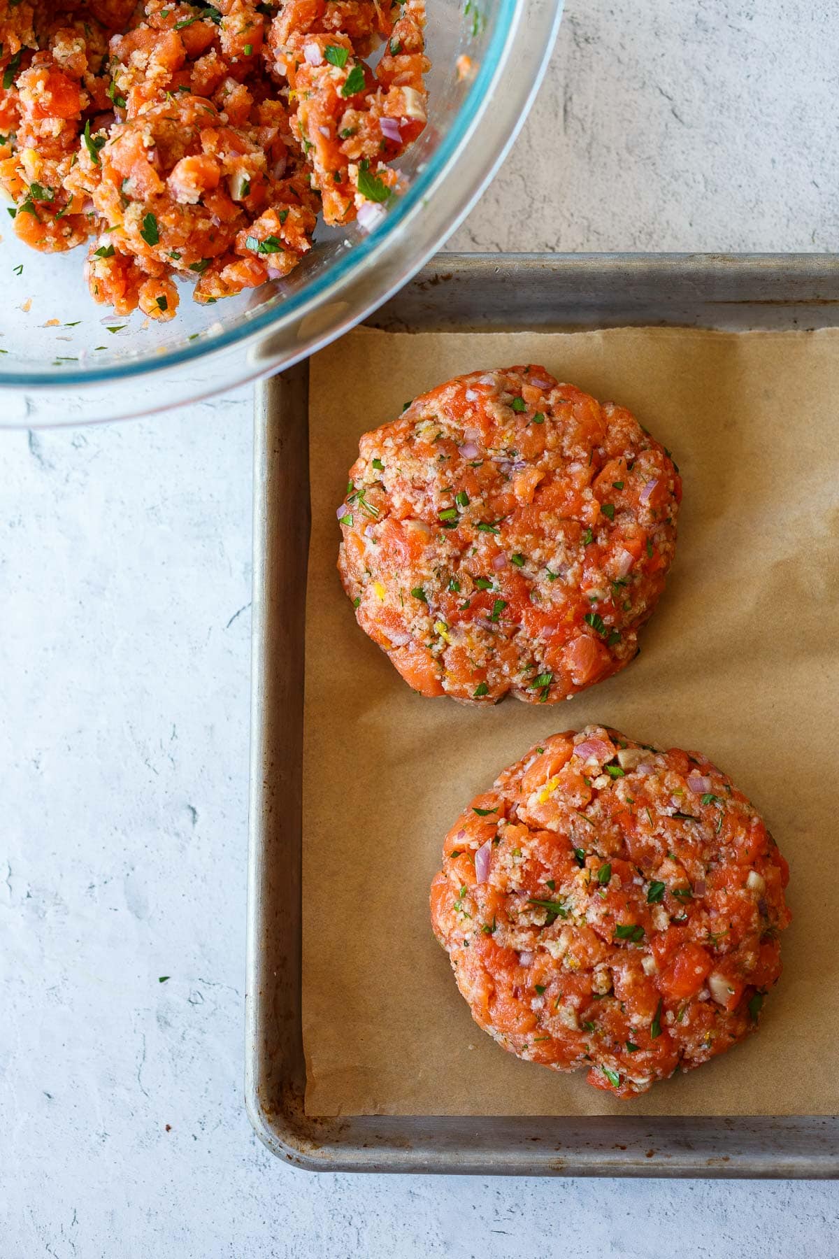 Salmon burgers formed on a sheet tray.