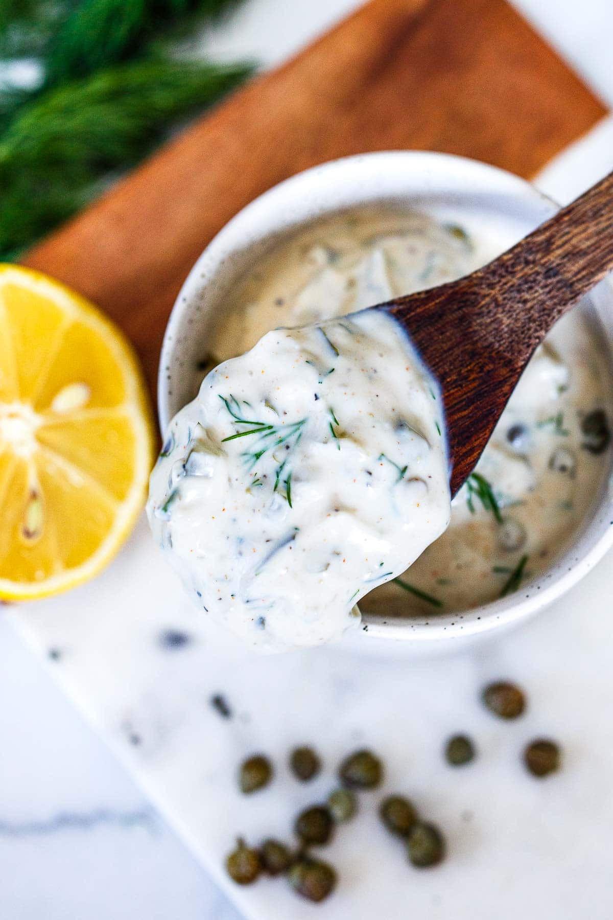 Homemade Tatar sauce in a bowl with a wood spoon. 