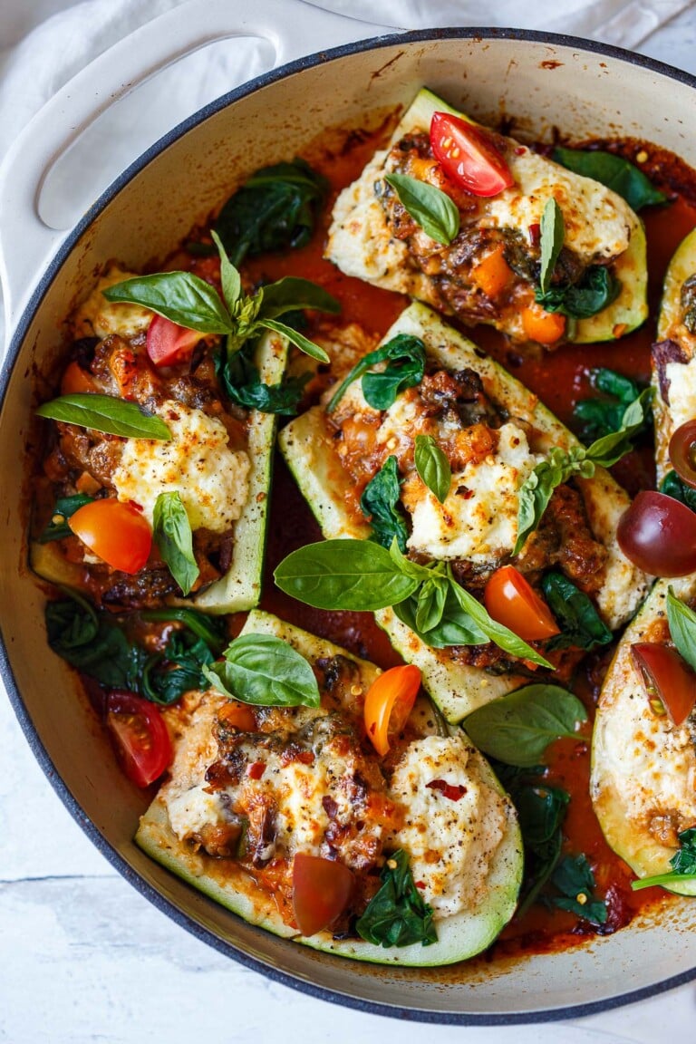 Tender zucchini is stuffed with a savory vegetarian filling of bell pepper, olives and spinach, topped with ricotta & baked in a marinara sauce.