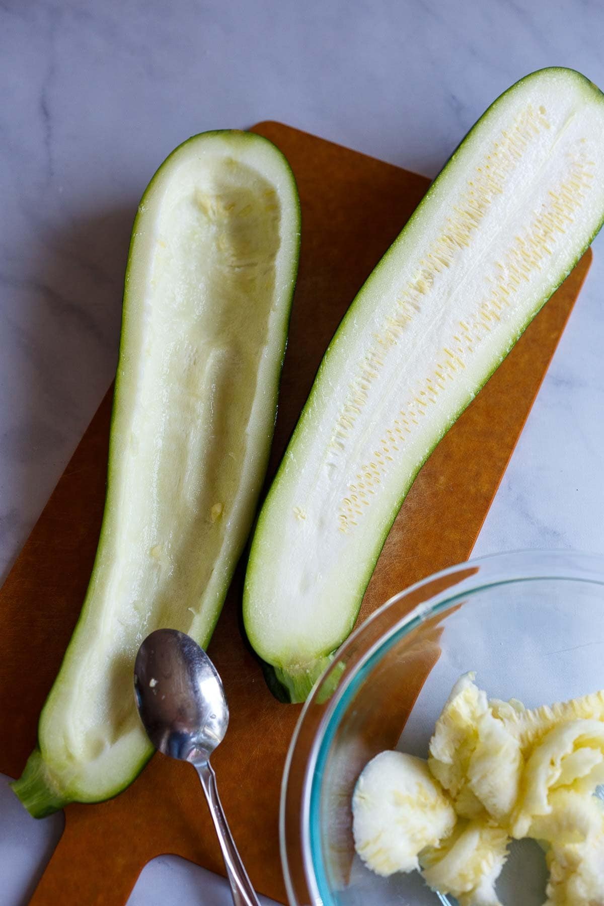 Zucchini sliced in half and holled out.