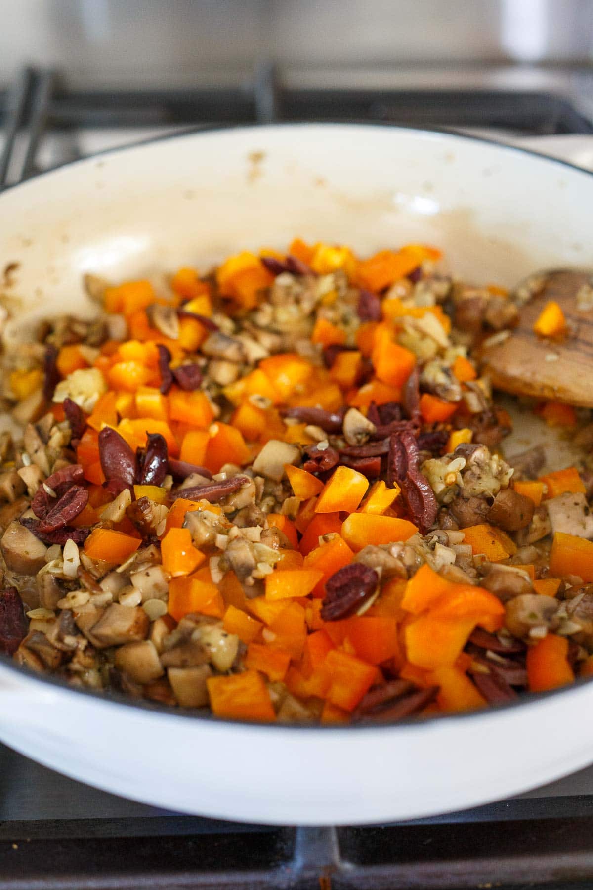 Veggies sauteing in a pan for Stuffed Zucchini.