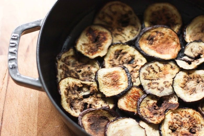 layers of roasted eggplant slices in round dutch oven.