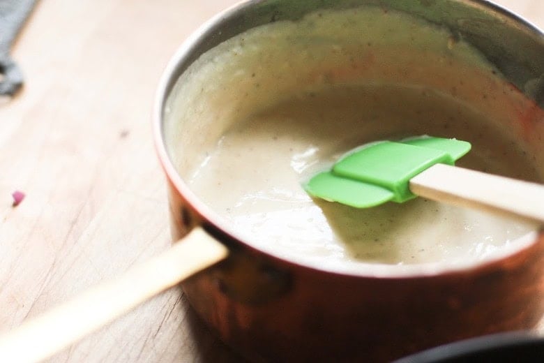 spatula in saucepan with béchamel sauce.