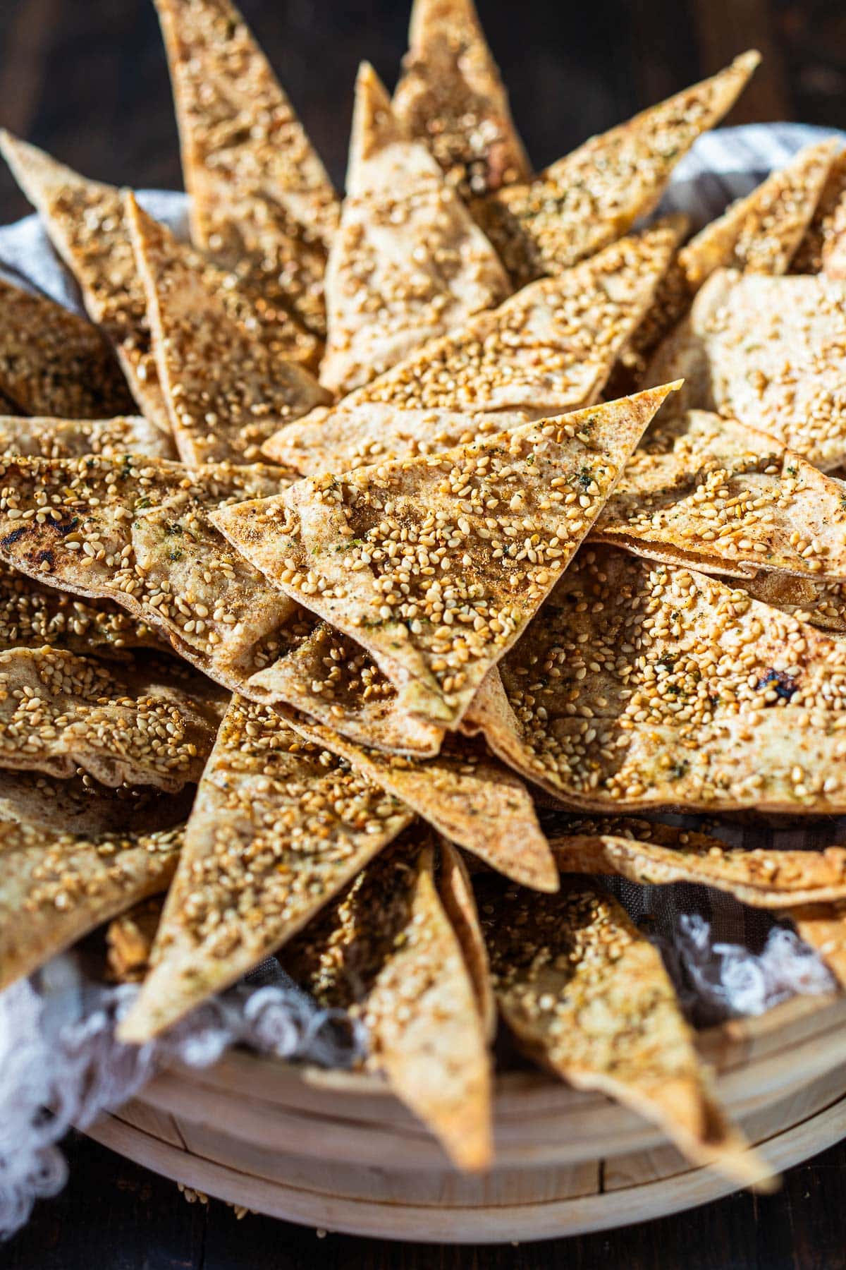 homemade baked pita chips with sesame seeds and spices in bucket