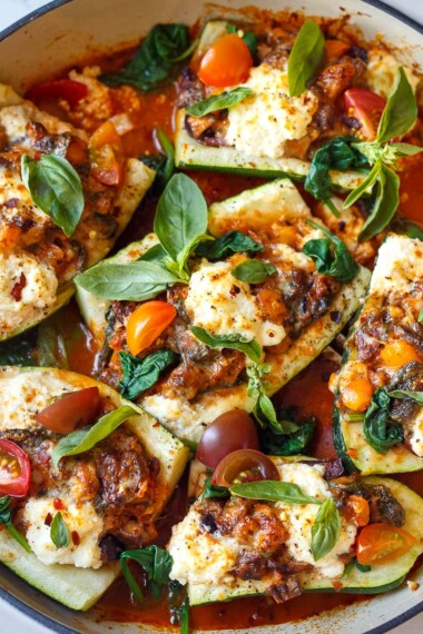 Tender zucchini is stuffed with a savory vegetarian filling of bell pepper, olives and spinach, topped with ricotta & baked in a marinara sauce.