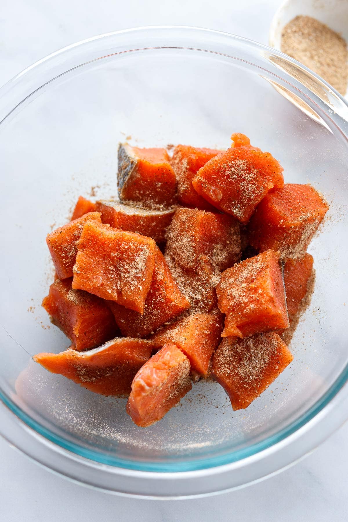 Spiced salmon cubes in a bowl.