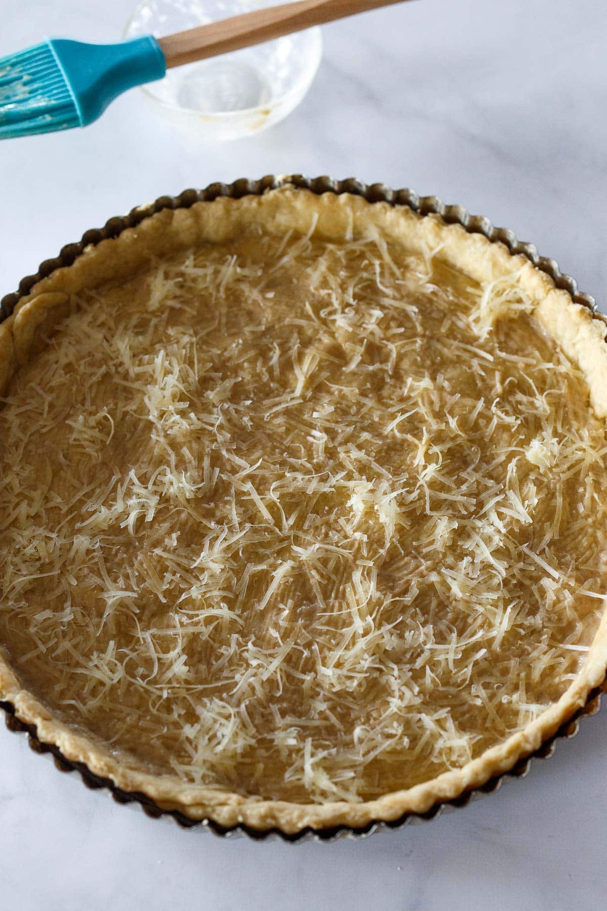 Parmesan cheese on tart crust for Tomato Tart.