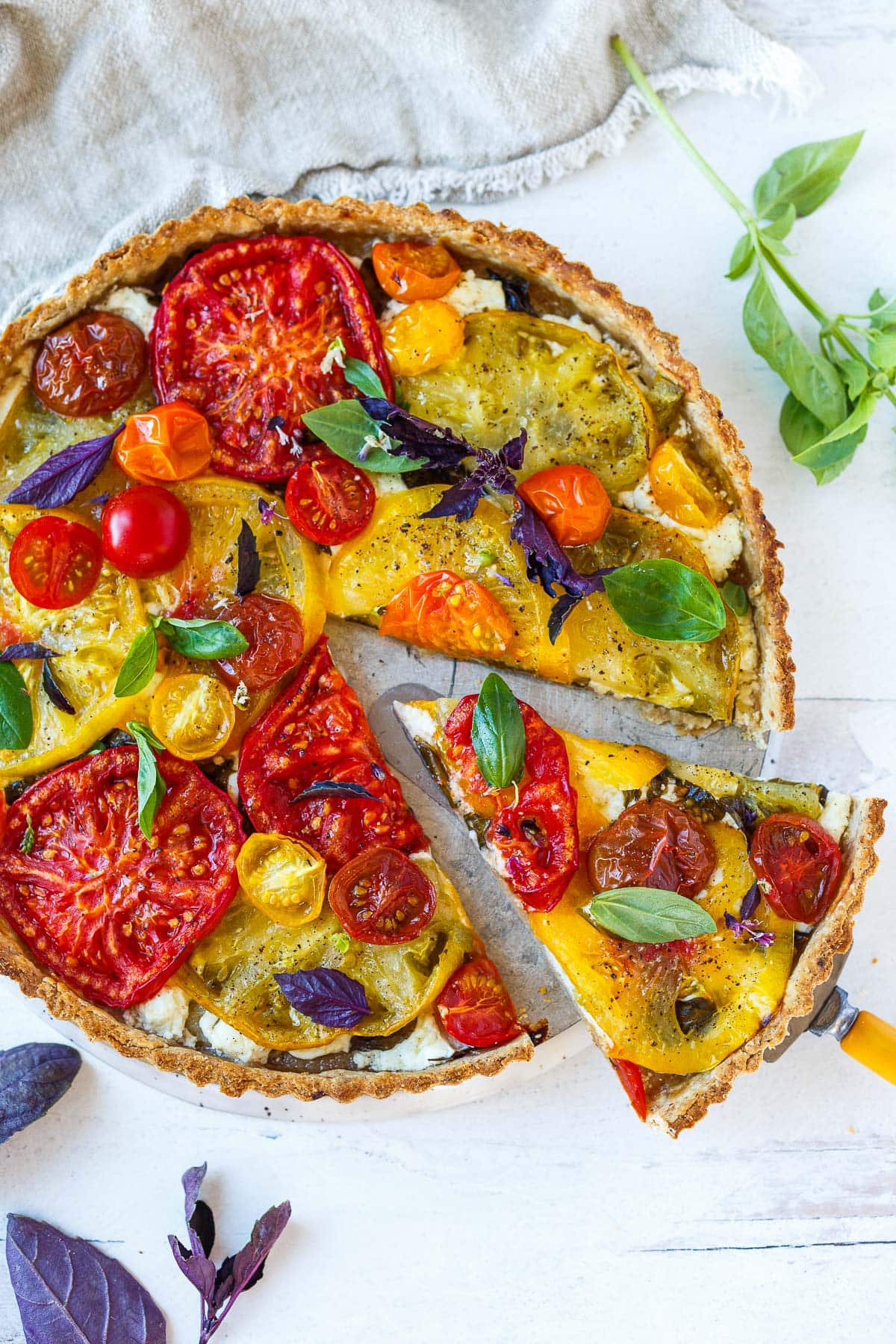 Elegant and savory, this fresh Tomato Tart is made with a flaky olive oil crust, juicy summer heirloom tomatoes, creamy goat cheese, and fresh basil.