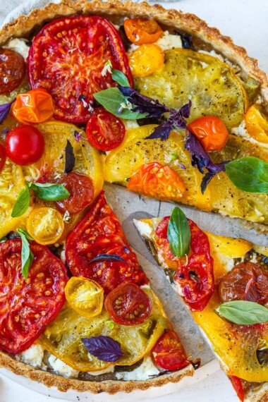 Elegant and savory, this fresh Tomato Tart is made with a flaky olive oil crust, juicy summer heirloom tomatoes, creamy goat cheese, and fresh basil.