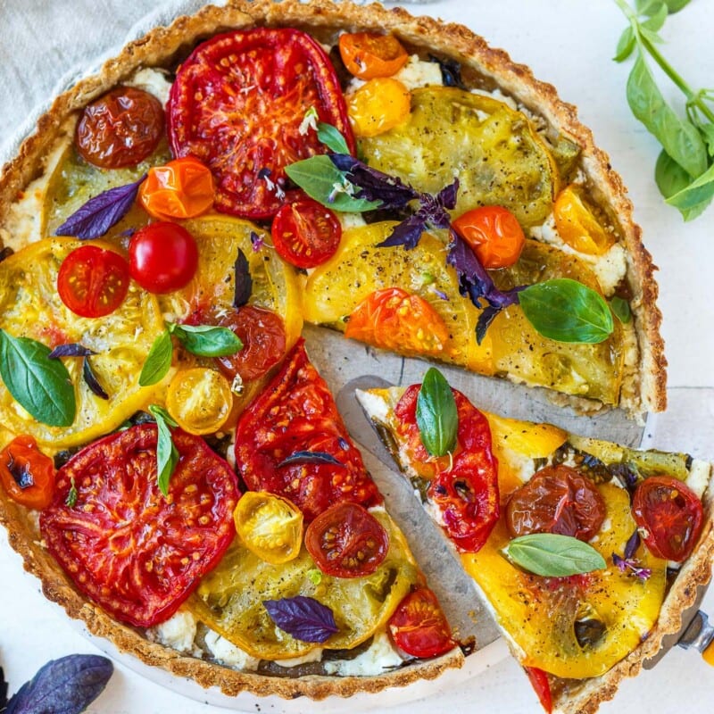 Elegant and savory, this fresh Tomato Tart is made with a flaky olive oil crust, juicy summer heirloom tomatoes, creamy goat cheese, and fresh basil.