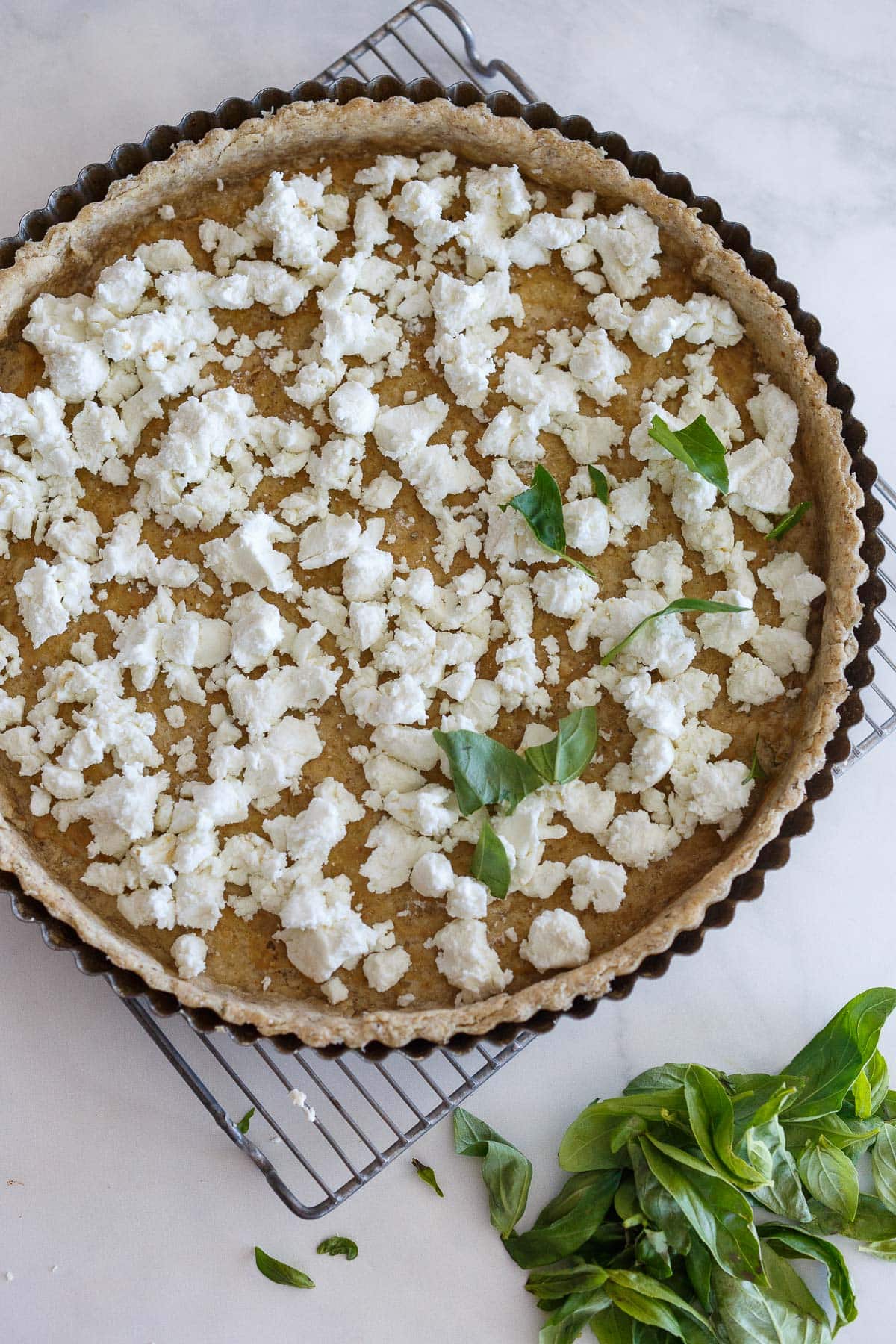 Goat cheese on tart crust for tomato tart.