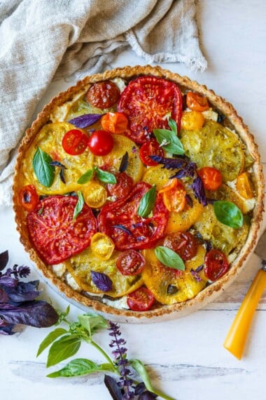 Elegant and savory, this fresh Tomato Tart is made with a flaky olive oil crust, juicy summer heirloom tomatoes, creamy goat cheese, and fresh basil.
