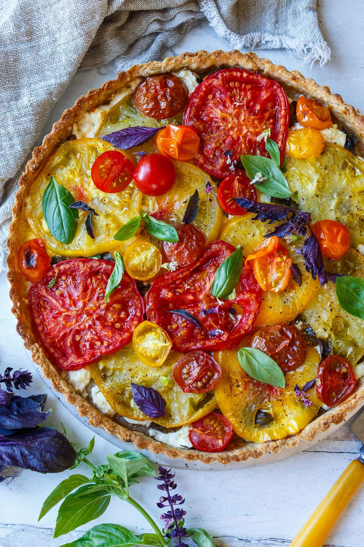 Tomato tart with basil in a tart pan.