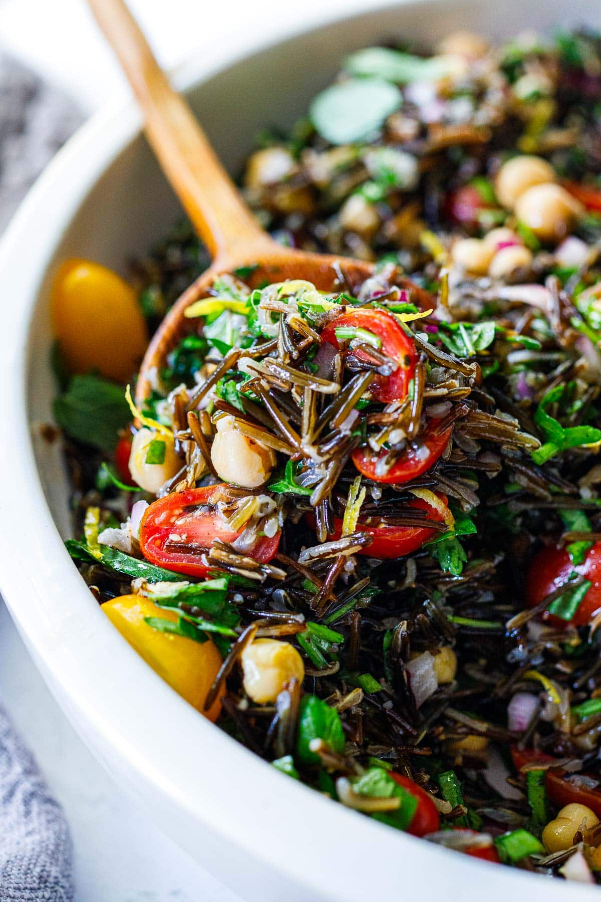 wood spoon with scoop of wild rice salad.