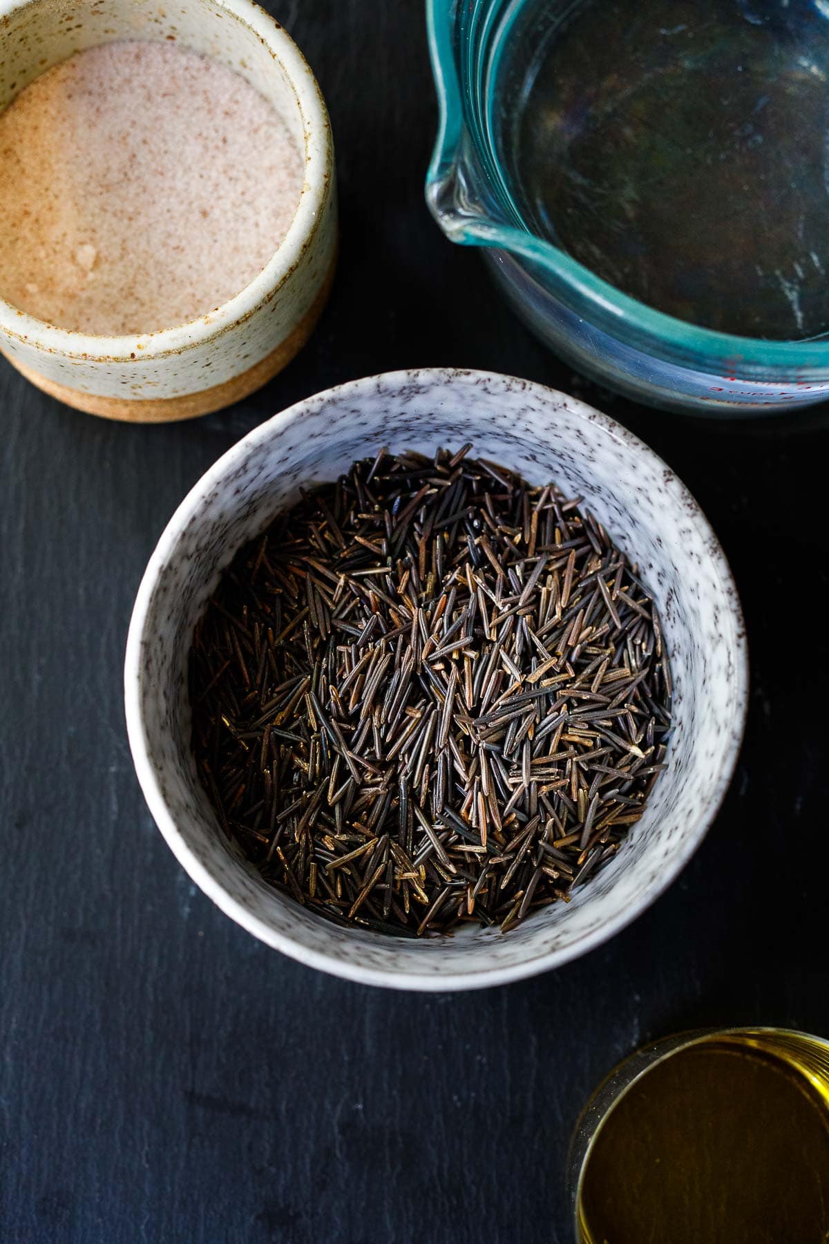 bowl of dried wild rice and salt, and water.