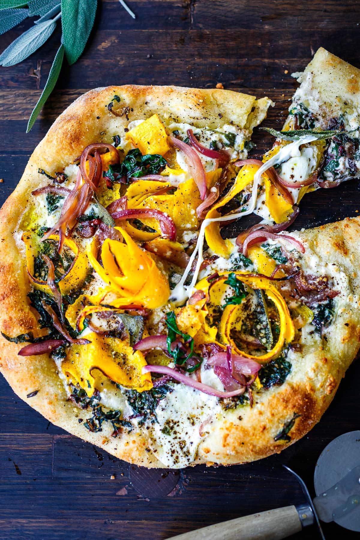 gooey, cheesy butternut squash pizza with a slice cut and pulled away