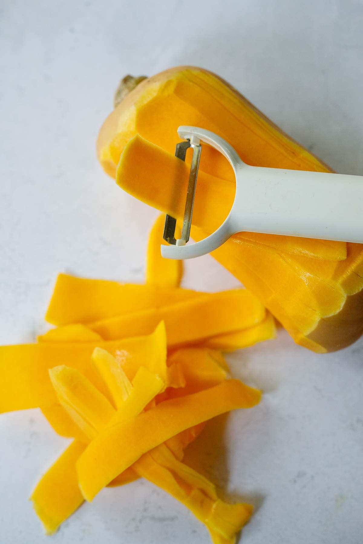 vegetable peeler peeling butternut squash