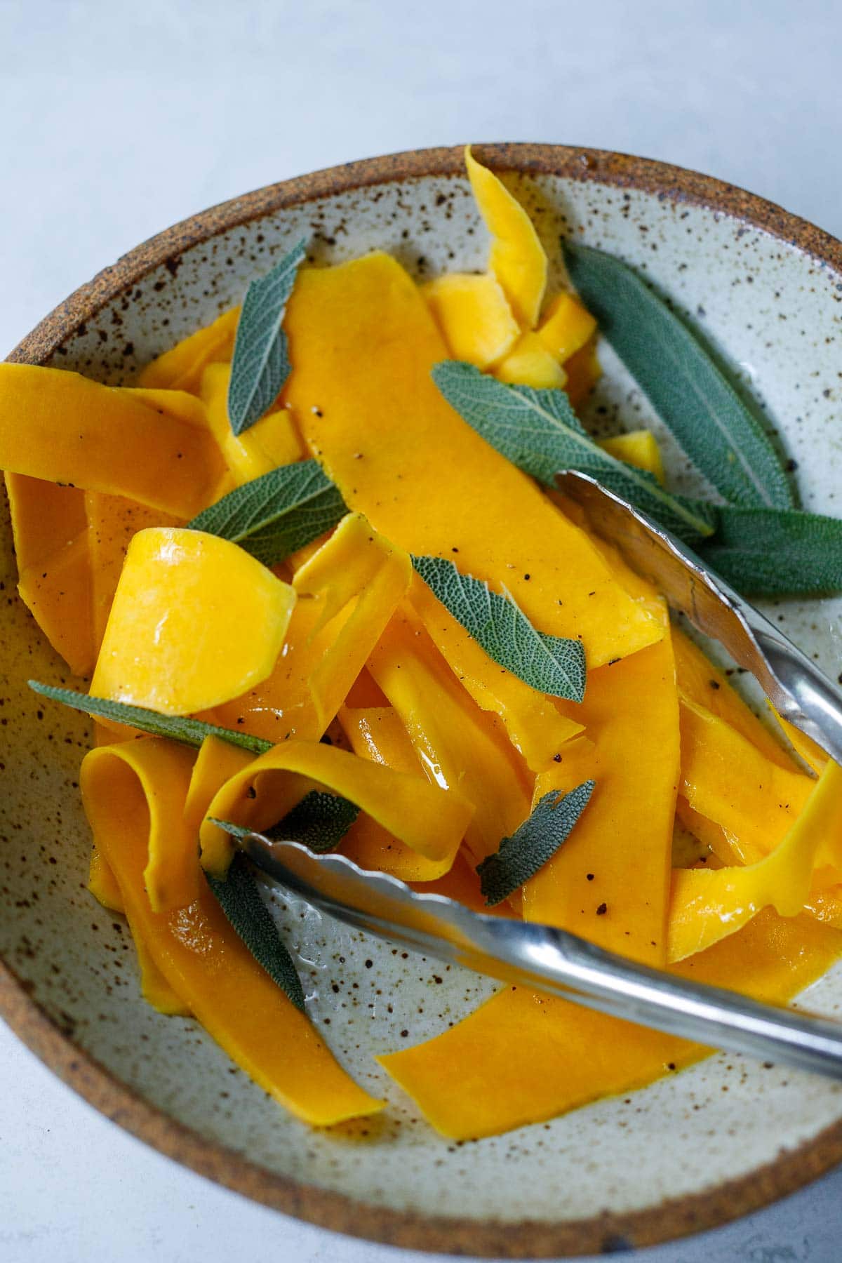 butternut squash strips in bowl with fresh sage