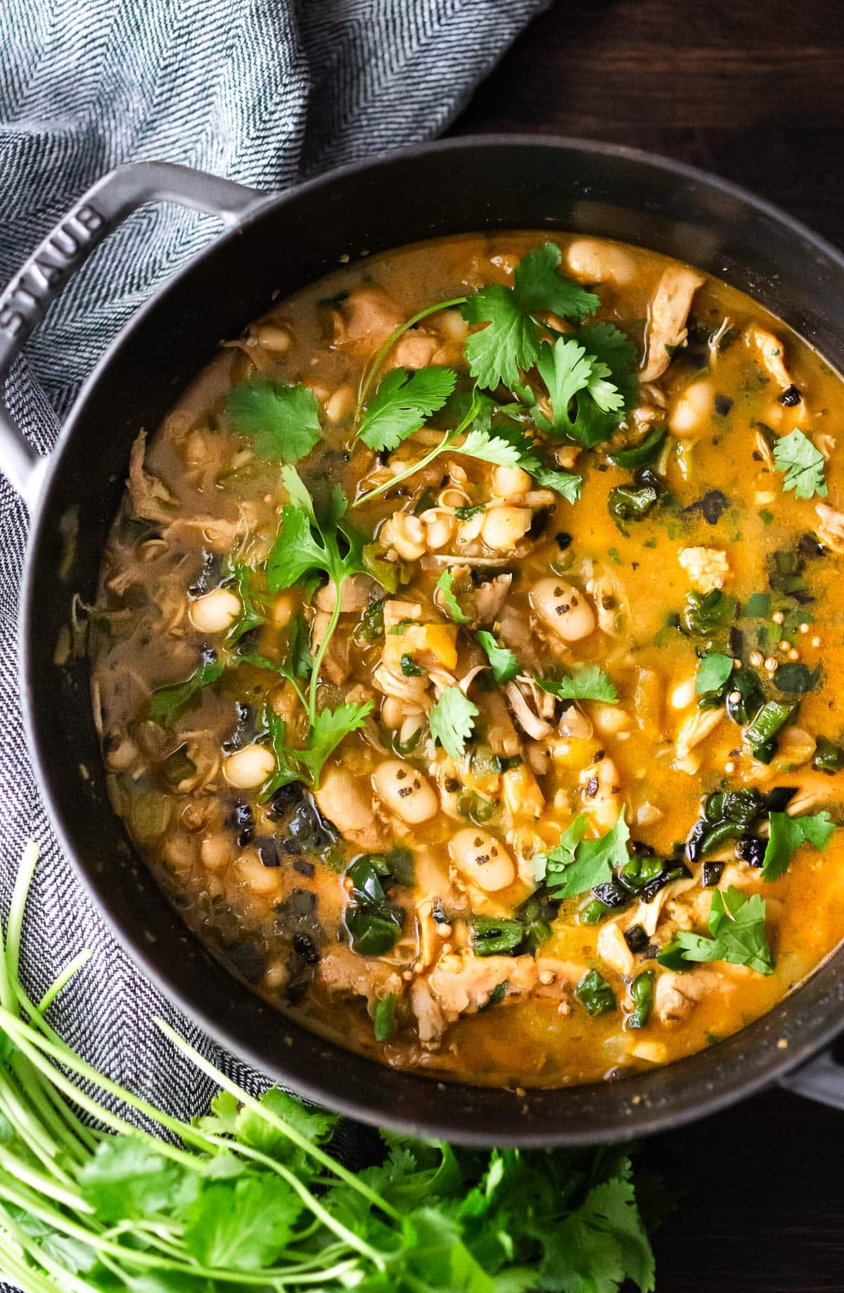 This delicious White Bean Chicken Chili is made with tender shredded chicken, white beans, poblano chilies, cilantro, coriander and lime- a tasty one-pot meal the whole family will love! www.feastingathome.com