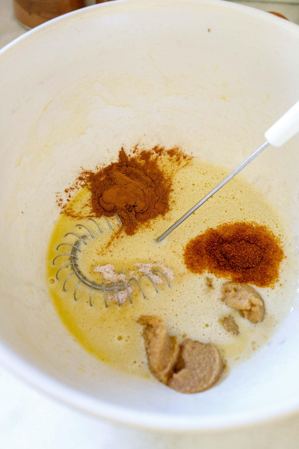 mixing bowl with whisked eggs, cinnamon, cayenne, ginger paste and salt with a whisk