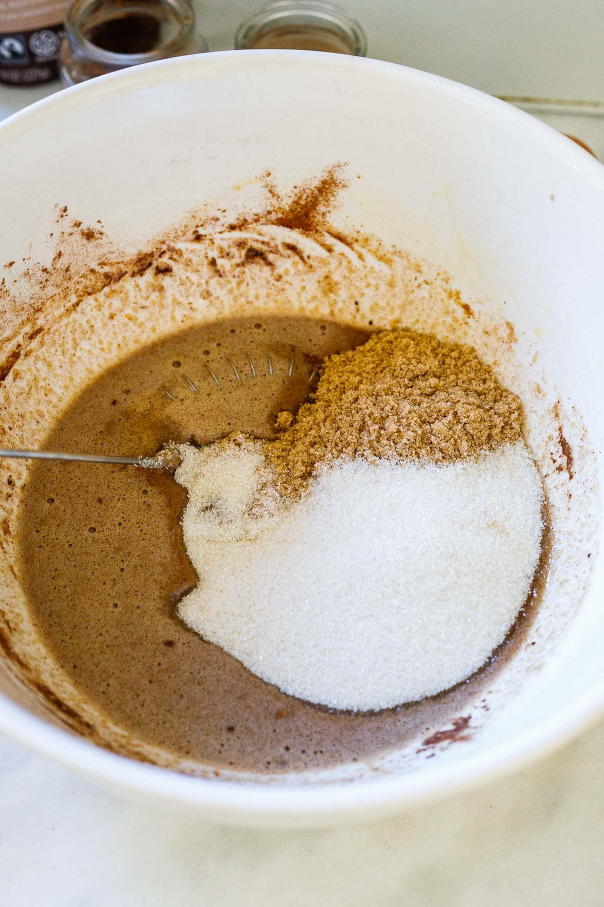 mixing bowl with brown sugar and cane sugar and a whisk