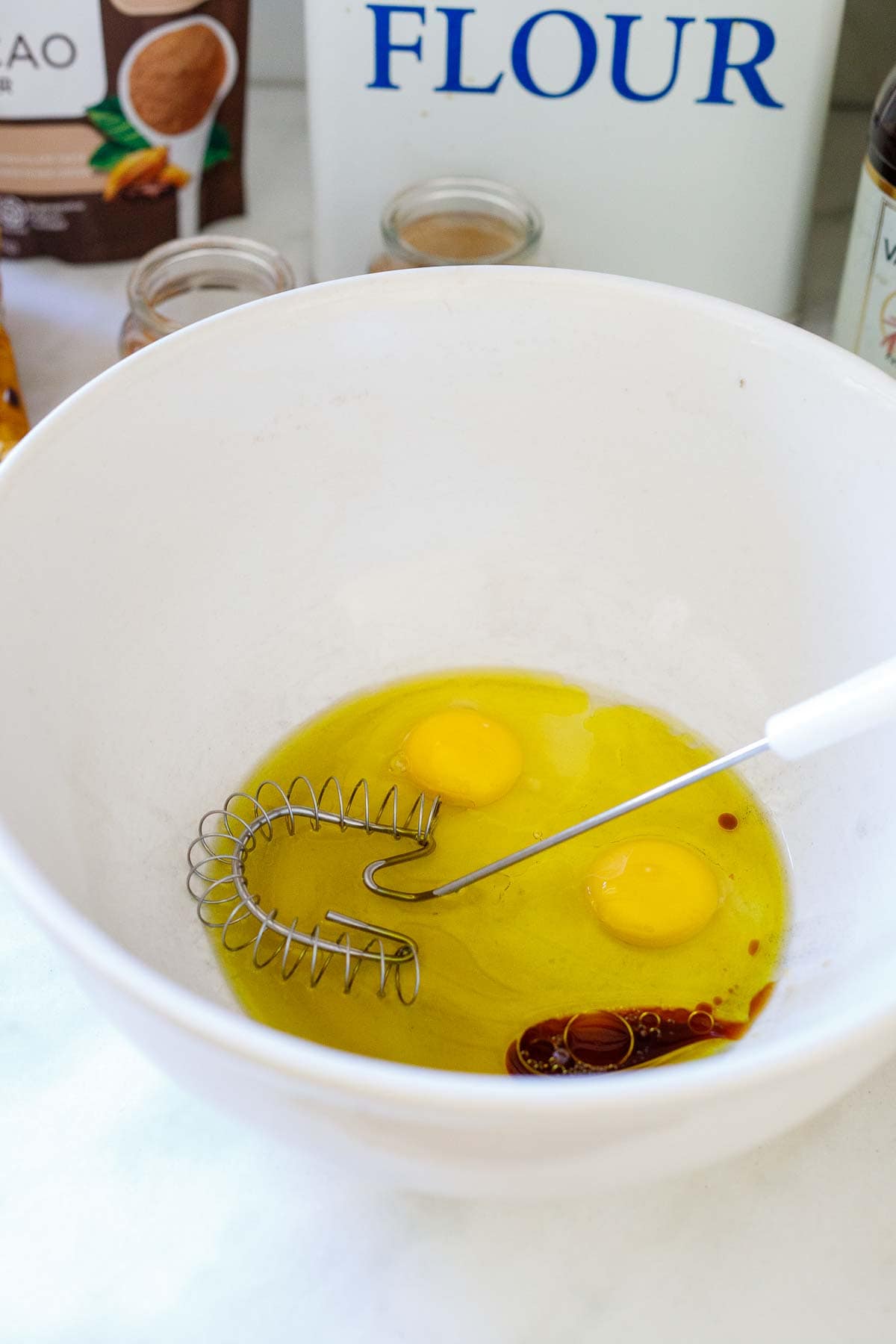 eggs in bowl with vanilla extract and a whisk