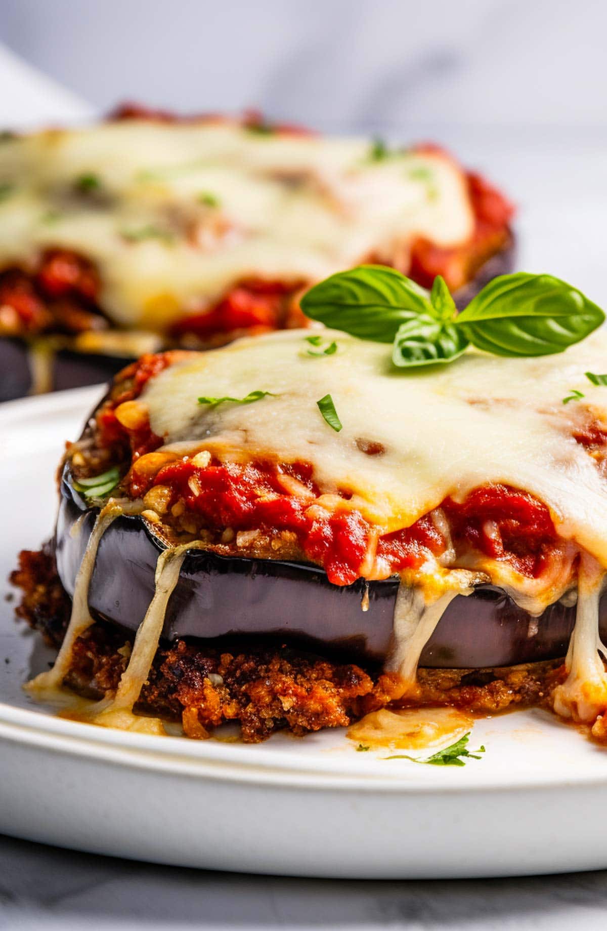  eggplant parmesan on plate with fresh basil garnish